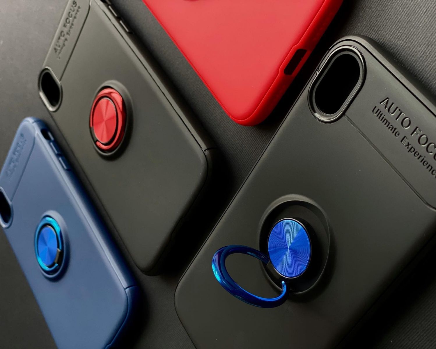 smartphone cases lie on a black canvas